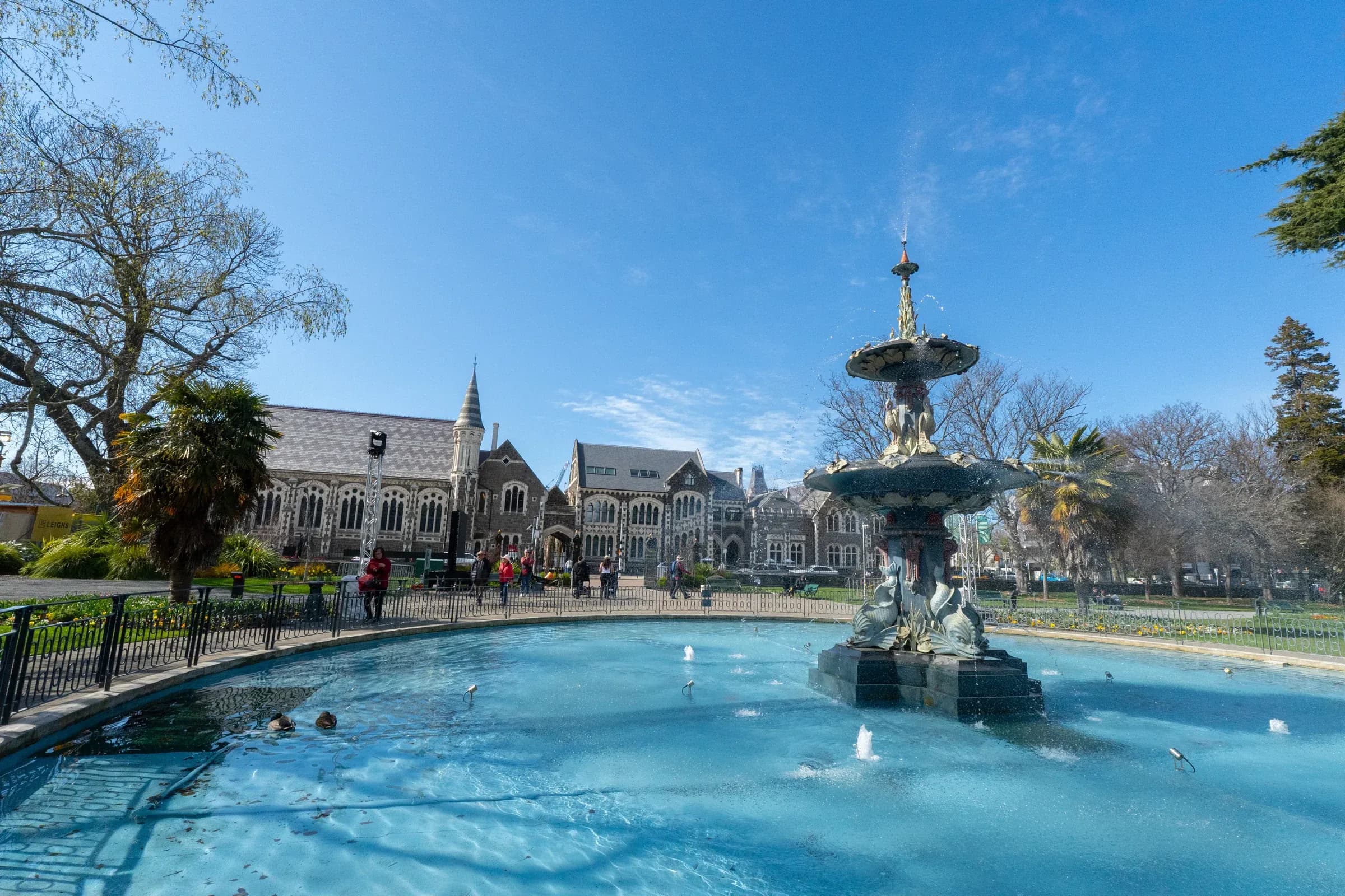 Peacock Fountain splashes beneath a bright blue sky.